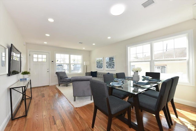 dining space with baseboards, visible vents, wood finished floors, and recessed lighting