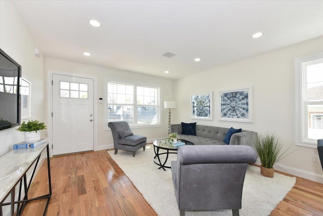 living area featuring visible vents, recessed lighting, baseboards, and light wood-style floors