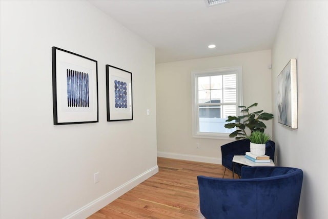 sitting room with baseboards, recessed lighting, and light wood-style floors