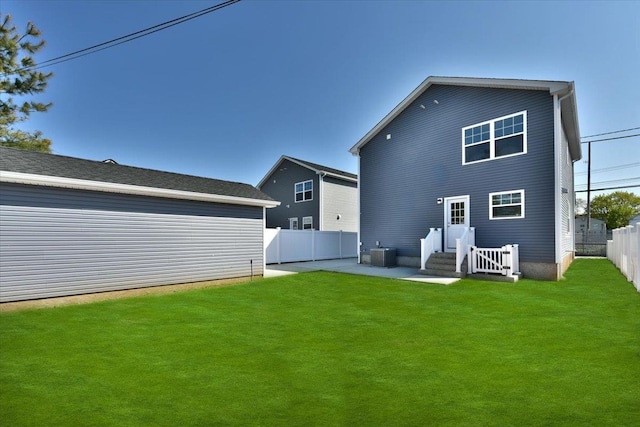 back of property featuring a lawn, central air condition unit, a patio, and a fenced backyard
