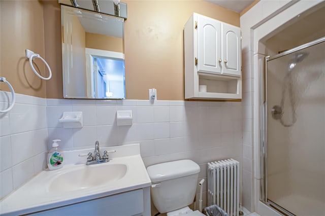bathroom with radiator heating unit, vanity, tile walls, and a stall shower