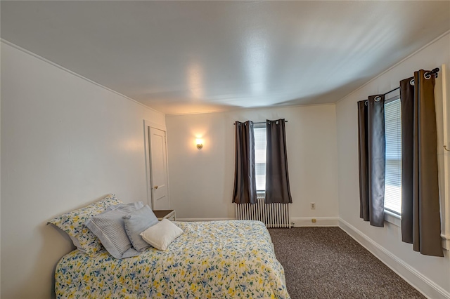bedroom with radiator heating unit, carpet, and baseboards