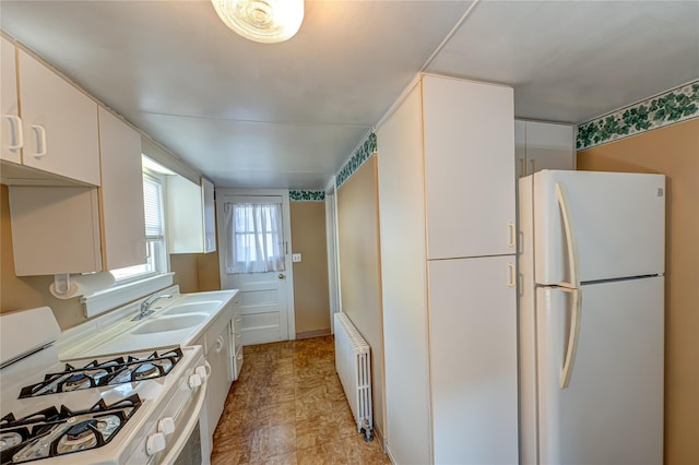 kitchen featuring light countertops, white appliances, a sink, and radiator