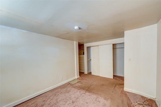 unfurnished bedroom featuring baseboards, carpet flooring, and a closet