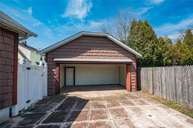 garage featuring fence and a gate