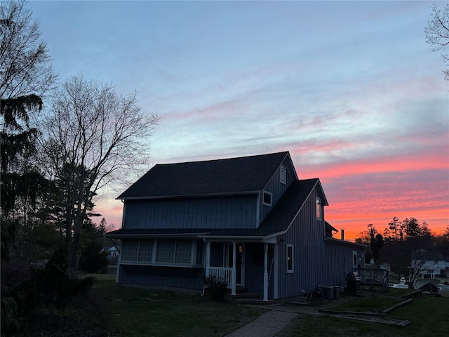 view of front facade featuring central AC, a porch, and a front yard