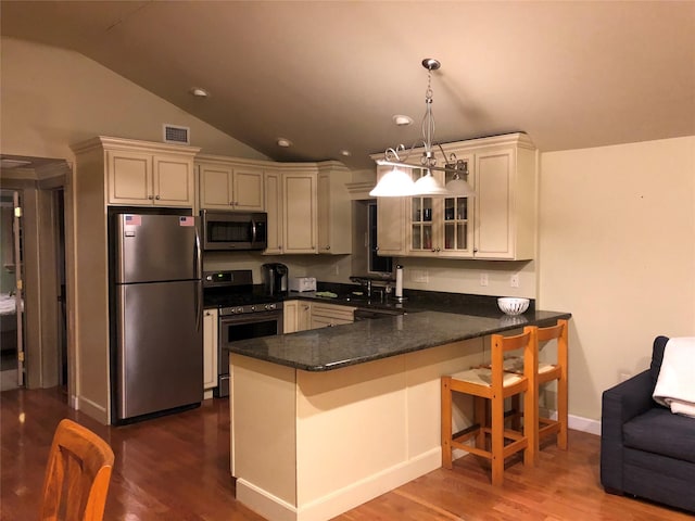 kitchen featuring lofted ceiling, visible vents, a peninsula, glass insert cabinets, and appliances with stainless steel finishes