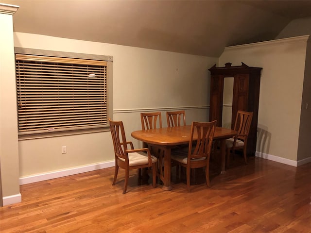 dining room with baseboards, wood finished floors, and lofted ceiling