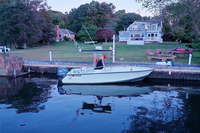 dock area featuring a deck with water view and a yard
