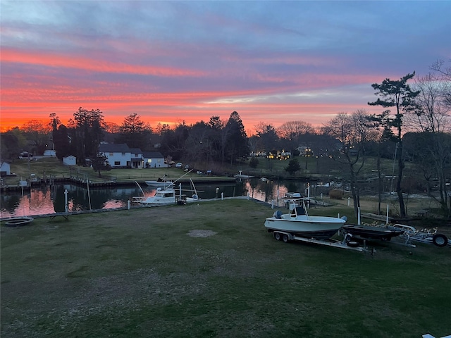 view of yard featuring a water view and a dock