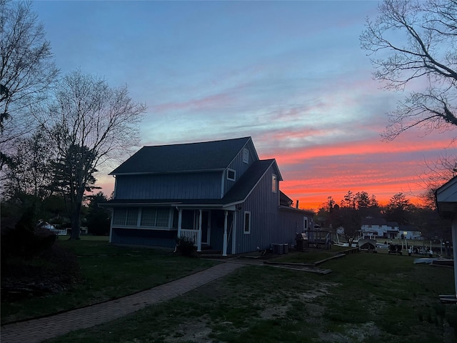 view of front of property with a porch, central air condition unit, and a lawn