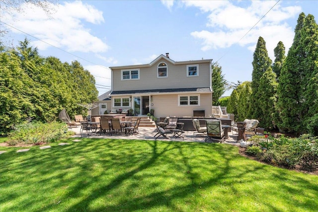 rear view of property with a lawn, a chimney, and a patio