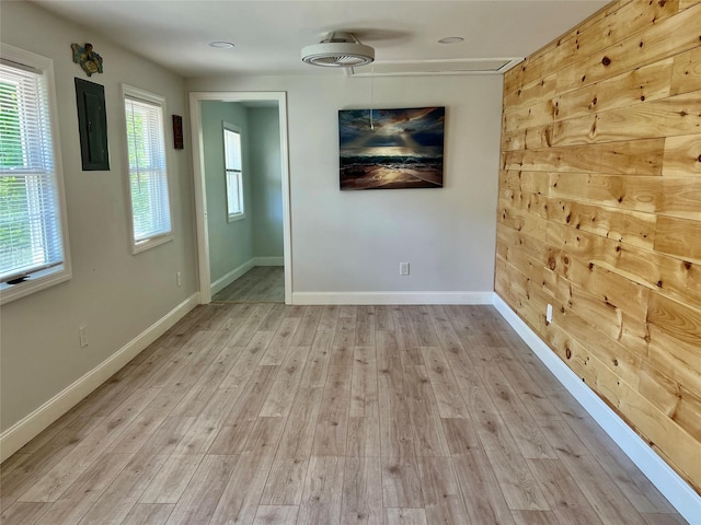 unfurnished room featuring electric panel, wood finished floors, and baseboards