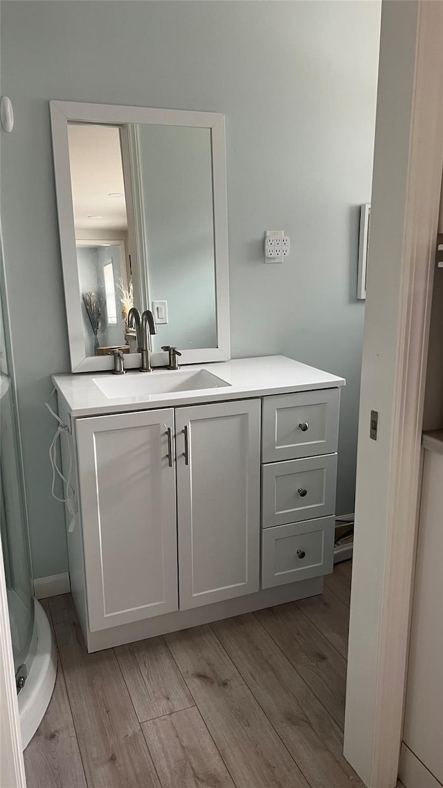 bathroom with wood finished floors and vanity