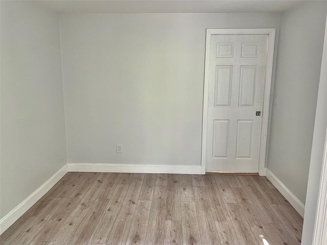 empty room with baseboards and light wood finished floors