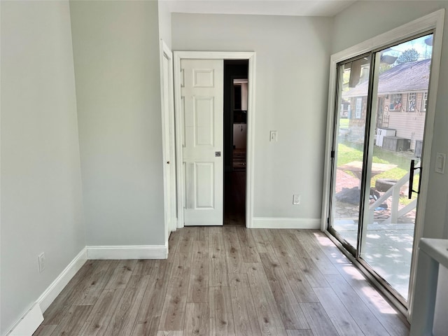 unfurnished room featuring light wood finished floors and baseboards