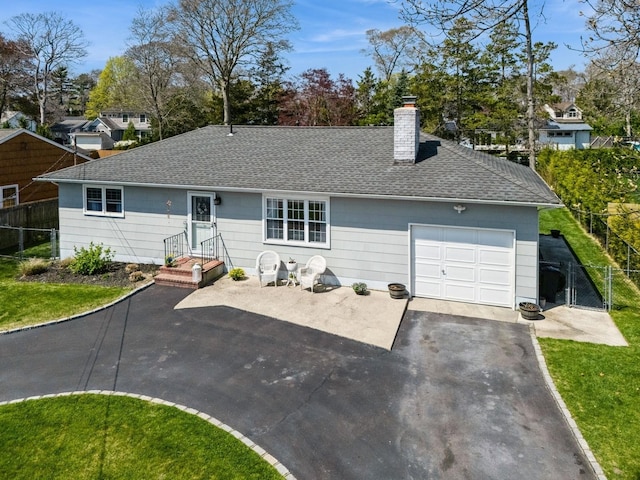 ranch-style home with a shingled roof, aphalt driveway, a chimney, an attached garage, and fence