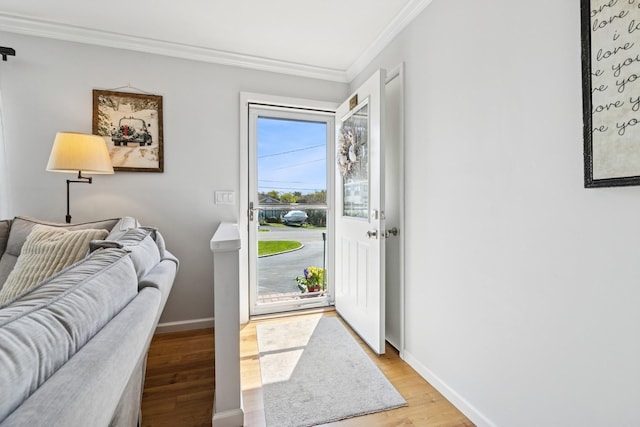 entryway featuring baseboards, ornamental molding, and light wood-style floors