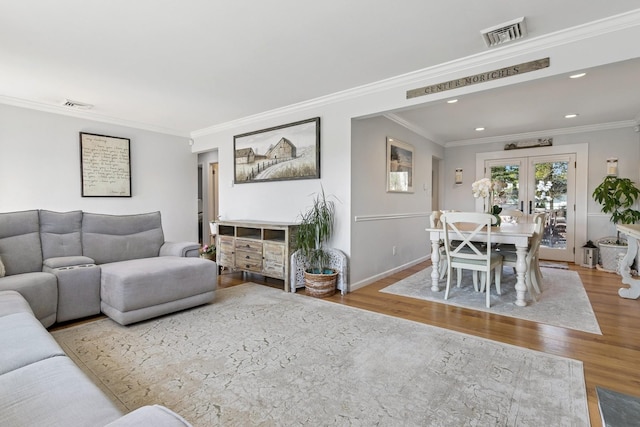living area featuring crown molding, visible vents, and wood finished floors