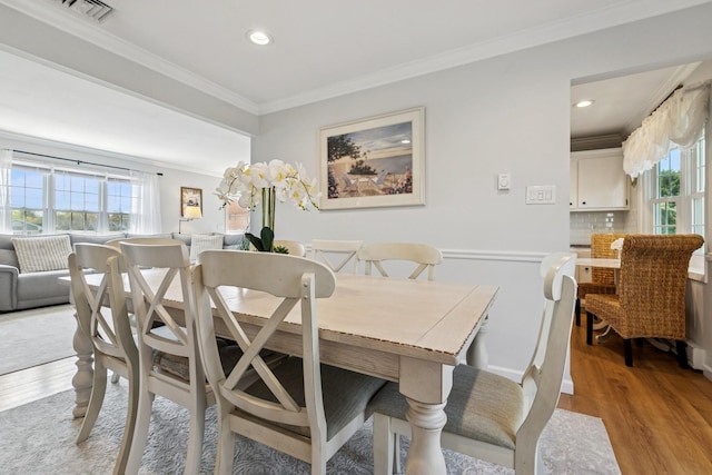 dining area with crown molding, recessed lighting, visible vents, and light wood-type flooring