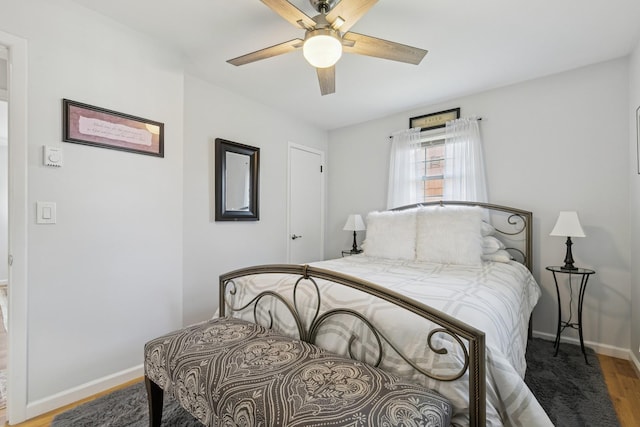 bedroom featuring wood finished floors, a ceiling fan, and baseboards