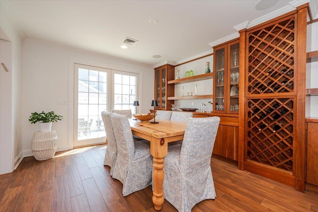 dining room with ornamental molding, recessed lighting, visible vents, and dark wood-style flooring