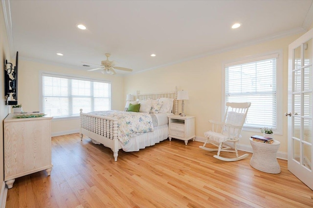 bedroom featuring baseboards, ornamental molding, light wood-style floors, and multiple windows