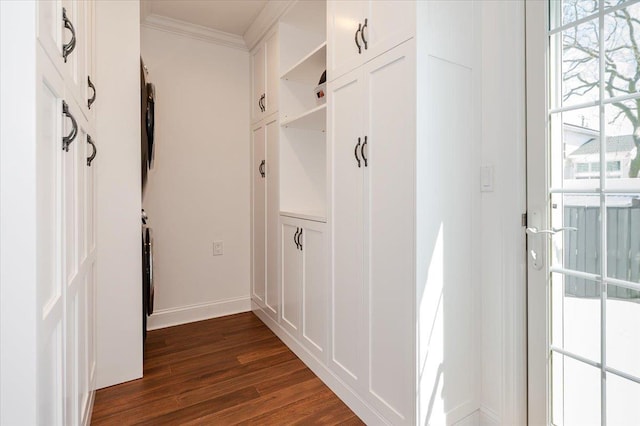 mudroom featuring dark wood-type flooring, crown molding, and baseboards