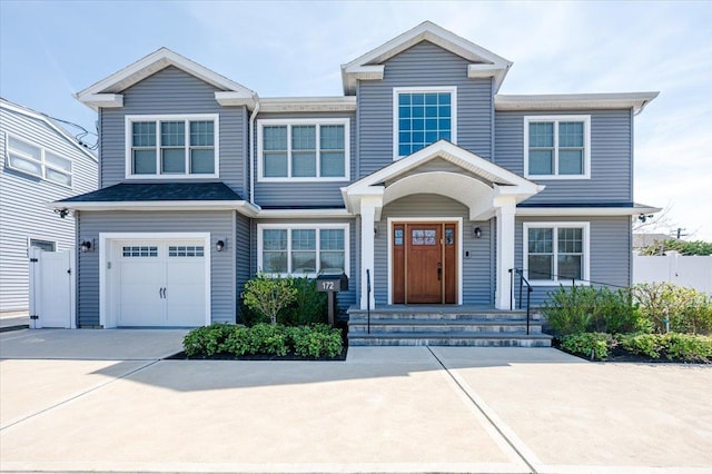 view of front of home featuring driveway, a garage, and fence
