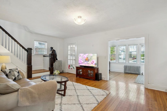 living area featuring stairway, radiator, and a wealth of natural light