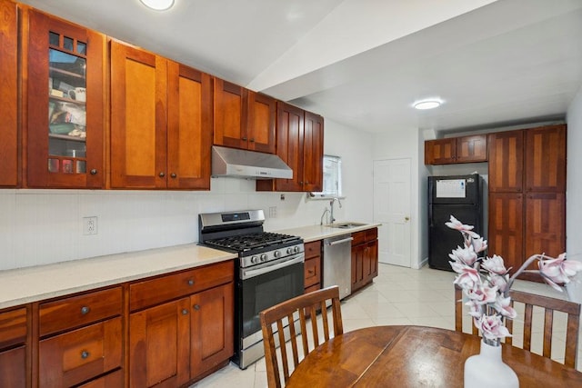 kitchen with under cabinet range hood, light tile patterned floors, appliances with stainless steel finishes, and a sink