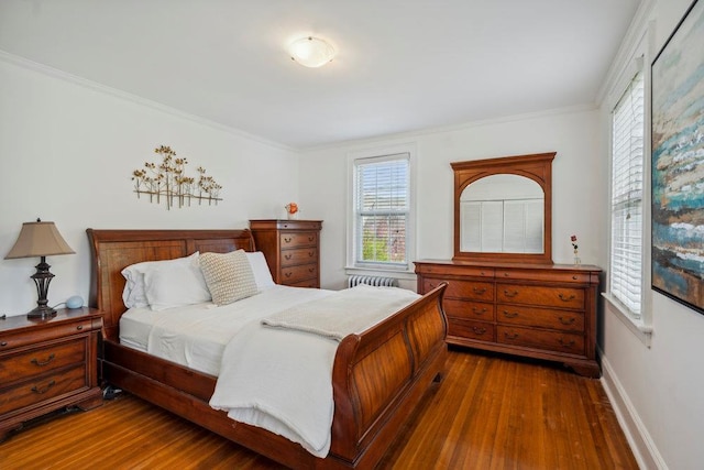 bedroom featuring crown molding, multiple windows, wood finished floors, and radiator
