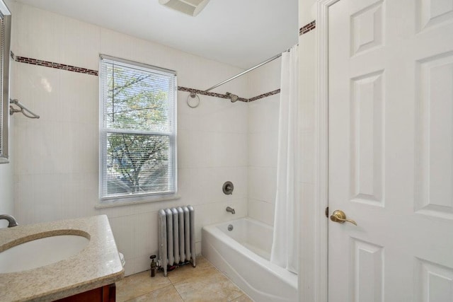 full bath featuring tile patterned floors, radiator heating unit, shower / bath combo, and vanity