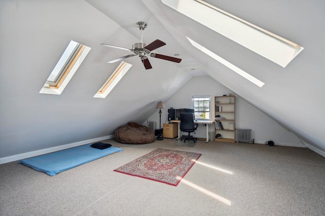 interior space featuring a ceiling fan, radiator, and lofted ceiling with skylight