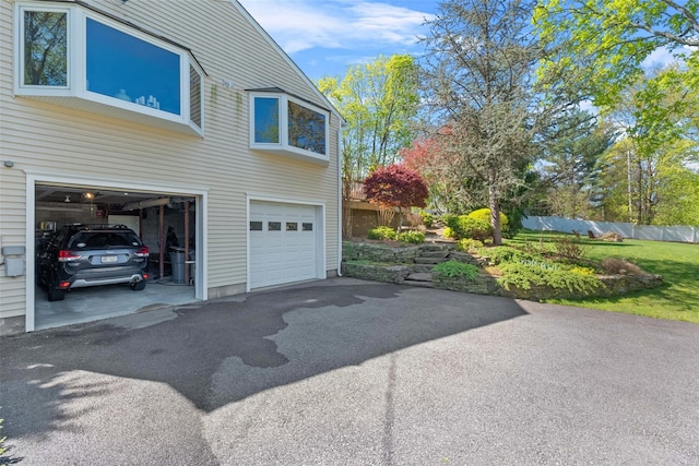 21 Rhinecliff Rd, Brewster, NY 10509 - view of side of home featuring an attached garage, aphalt driveway, and fence