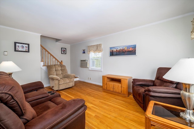 living room featuring an AC wall unit, light wood-type flooring, baseboards, stairs, and ornamental molding