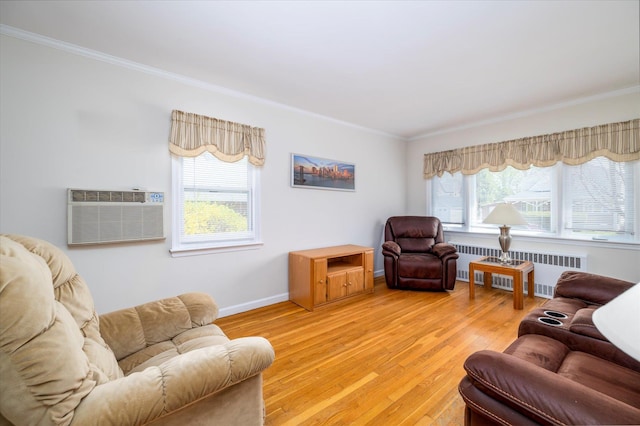living area featuring radiator, a wall mounted air conditioner, light wood finished floors, crown molding, and baseboards