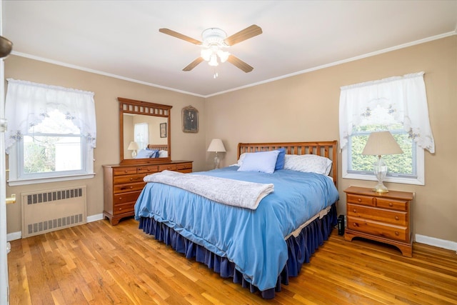 bedroom with light wood-style floors, ornamental molding, and radiator