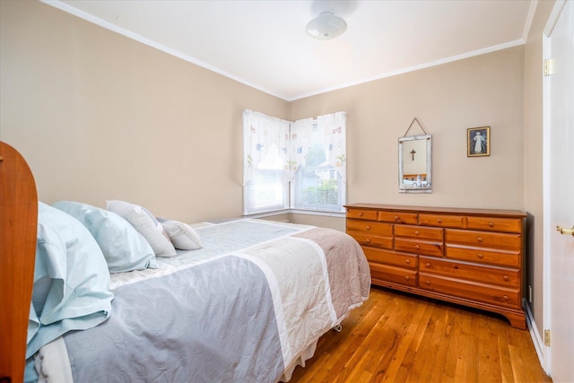 bedroom featuring wood finished floors, baseboards, and ornamental molding