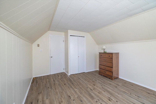 additional living space featuring vaulted ceiling and wood finished floors