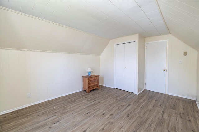 additional living space featuring vaulted ceiling and wood finished floors