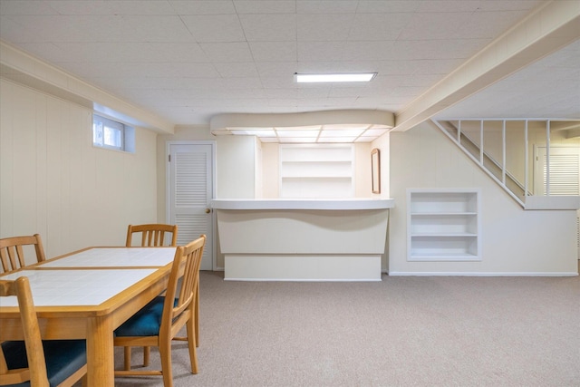 carpeted dining area with built in features and baseboards