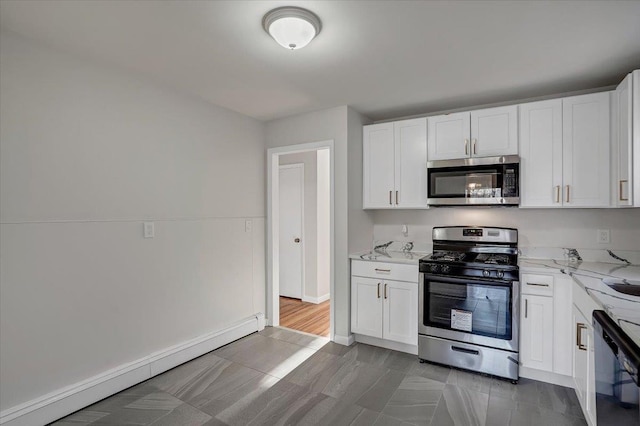 kitchen with white cabinetry, light stone counters, appliances with stainless steel finishes, and a baseboard radiator