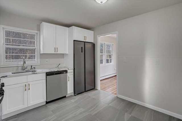 kitchen featuring a baseboard heating unit, a sink, stainless steel appliances, and plenty of natural light