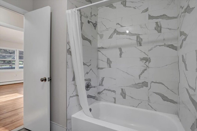 bathroom featuring shower / bath combo with shower curtain and a baseboard radiator