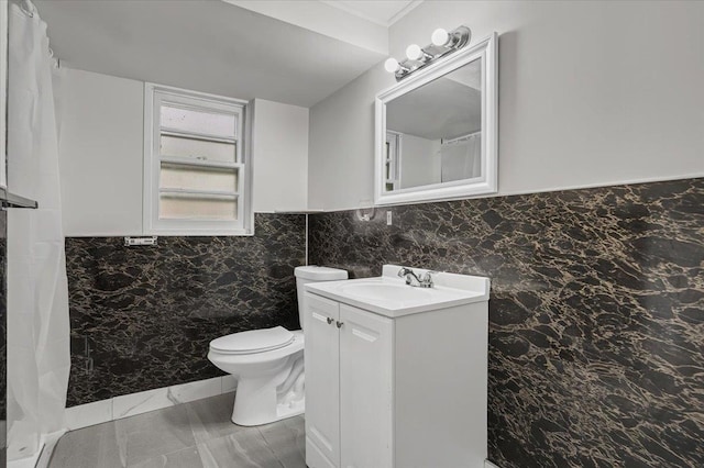 full bathroom with a shower with curtain, vanity, toilet, marble finish floor, and wainscoting