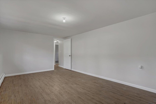 spare room featuring wood finished floors and baseboards