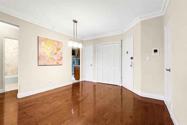 unfurnished dining area featuring ornamental molding, baseboards, and wood finished floors