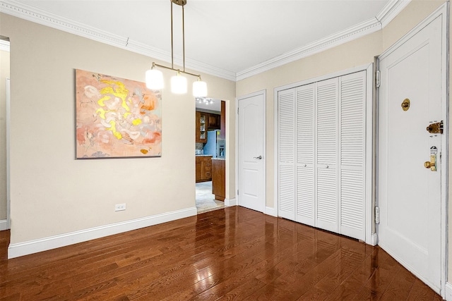 unfurnished dining area with baseboards, ornamental molding, and wood finished floors