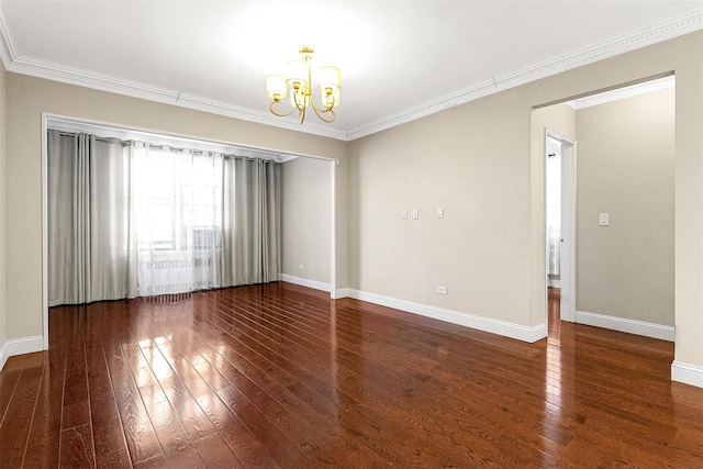 empty room featuring a chandelier, baseboards, and wood-type flooring